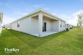 Kissimmee house for rent - a row of white houses with a lawn and grass