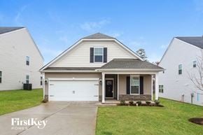 Greenville house for rent - a white house with a white garage door and a green lawn