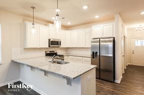 Greenville house for rent - a kitchen with white cabinets and a granite counter top