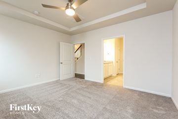 Greenville house for rent - a spacious living room with carpet and a ceiling fan