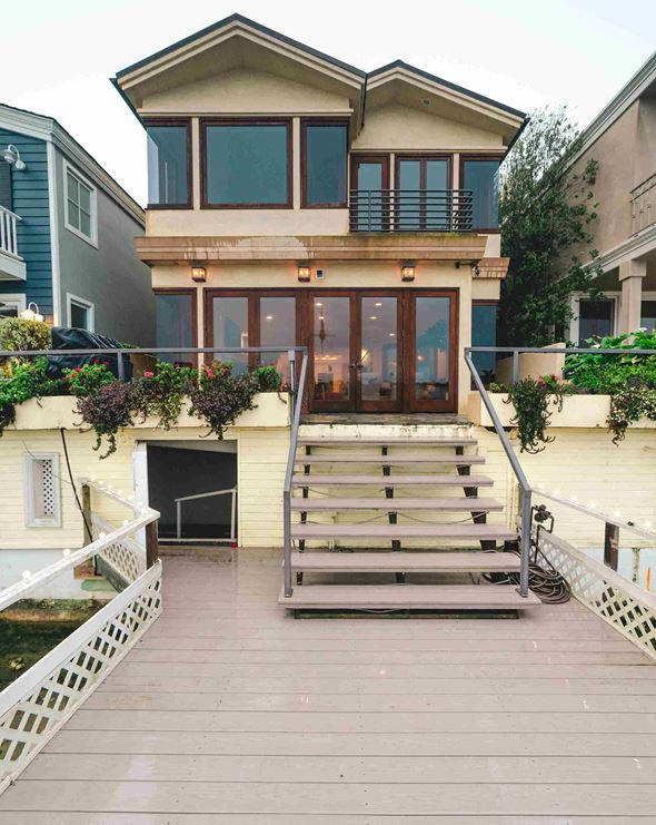Newport Beach apartment for rent - the front of a house with a wooden deck and stairs