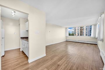 New Westminster apartment for rent - A spacious room with wooden floors and white walls.