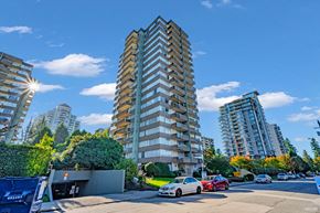New Westminster apartment for rent - A tall building with a lot of windows is in the middle of a street with cars and trees.
