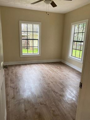 El Campo house for rent - an empty room with a hard wood floor and two windows
