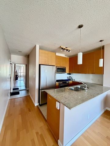Port Moody apartment for rent - A kitchen with wooden cabinets and a granite countertop.