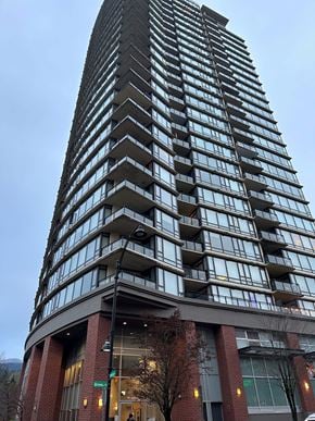 Port Moody apartment for rent - A tall building with a curved base and balconies on each floor.