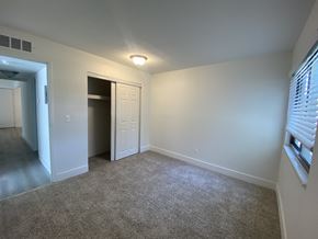 Clinton Township apartment for rent - an empty living room with a door to a closet and a window