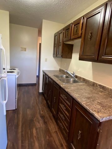 Hinton apartment for rent - A kitchen with brown cabinets and a granite countertop.