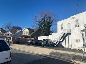 Baltimore apartment for rent - a city street with cars parked in front of a white house