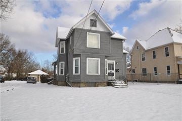 Warren apartment for rent - A grey house with a white roof and a snow-covered ground.