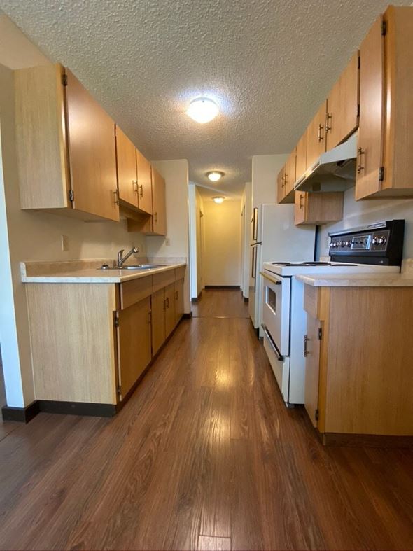 Hinton apartment for rent - A kitchen with wooden cabinets and a white refrigerator.