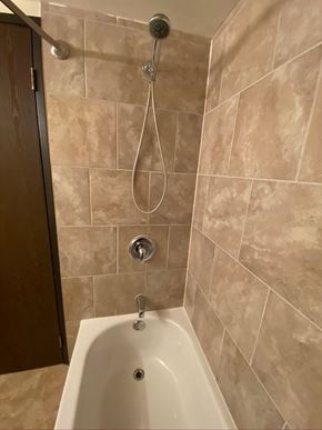 Hinton apartment for rent - A white bathtub with a shower head and hand held shower.