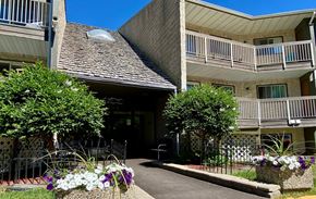 Hinton apartment for rent - A building with a balcony and a small garden in front.