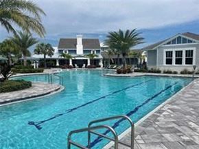 Parrish house for rent - a large swimming pool with a house in the background
