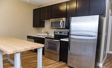 Fargo apartment for rent - a kitchen with stainless steel appliances and a wooden table