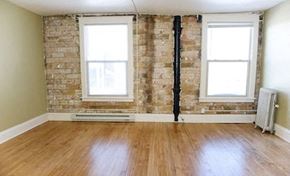 Fargo apartment for rent - an empty room with a wood floor and exposed brick wall