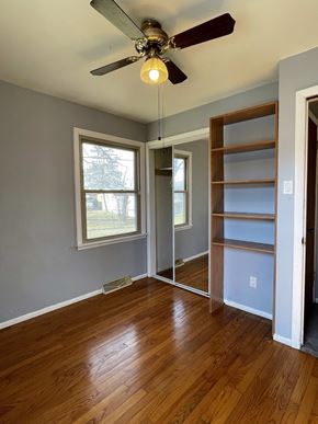Merrillville house for rent - an empty living room with wood floors and a ceiling fan