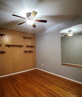 Merrillville house for rent - a bedroom with a wood floor and a ceiling fan