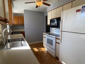Merrillville house for rent - an empty kitchen with white appliances and wood flooring