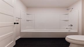 Hugo house for rent - A white bathroom with a toilet and a bathtub.