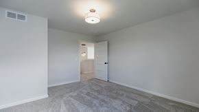 Hugo house for rent - A room with a carpeted floor and a ceiling light.