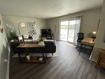 Speedway apartment for rent - A living room with a black couch and a wooden coffee table.