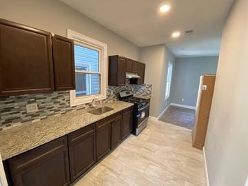 Elizabeth apartment for rent - A kitchen with brown cabinets and a stone countertop.