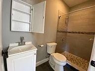 Elizabeth apartment for rent - A white toilet sits in a bathroom next to a sink and a shower.