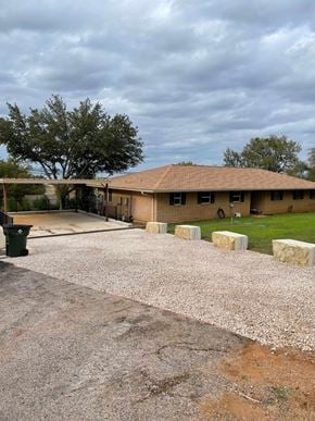 Buchanan Dam apartment for rent - A house with a brown roof and a driveway with gravel.