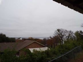 Buchanan Dam apartment for rent - A house with a brown roof is surrounded by trees and bushes.