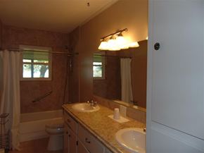 Burnet apartment for rent - A bathroom with a toilet, sink, and mirror.