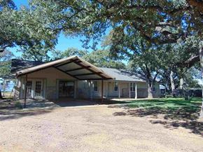Burnet apartment for rent - A house with a porch and a tree in front.