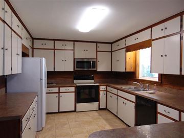 Burnet apartment for rent - A kitchen with white cabinets and brown countertops.