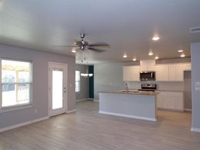 Burnet house for rent - an empty living room with a kitchen and a ceiling fan