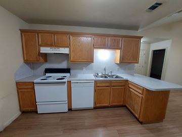 Marble Falls apartment for rent - A kitchen with wooden cabinets and white appliances.