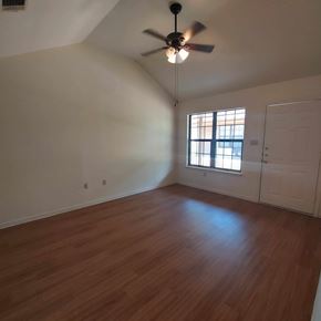 Marble Falls apartment for rent - A room with a ceiling fan and wooden floors.