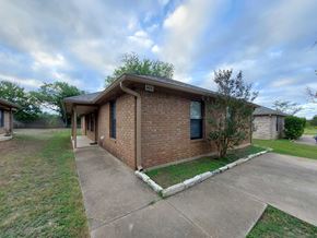 Marble Falls apartment for rent - A house with a brown brick exterior and a white trim around the windows and roofline.