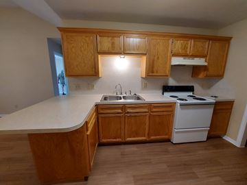 Marble Falls apartment for rent - A kitchen with wooden cabinets and a white countertop.