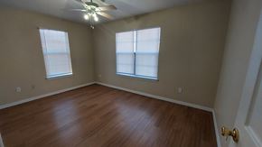 Marble Falls apartment for rent - A room with a ceiling fan and two windows.