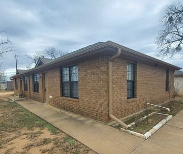 Marble Falls apartment for rent - A brick house with a brown roof and a white door.