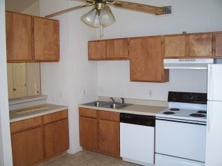 Marble Falls apartment for rent - A kitchen with brown cabinets and a white fridge.