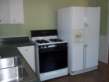 Austin apartment for rent - A white refrigerator stands in a kitchen next to a stove.