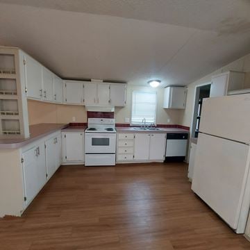 Marble Falls apartment for rent - A kitchen with white cabinets and a wooden floor.