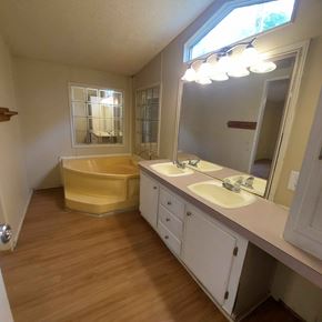 Marble Falls apartment for rent - A bathroom with a yellow bathtub and white cabinets.