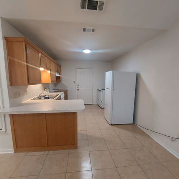 Marble Falls apartment for rent - A kitchen with a white counter top and wooden cabinets.