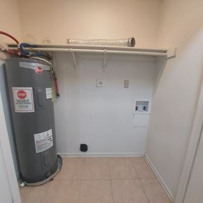 Marble Falls apartment for rent - A room with a water heater and a white shelf above it.