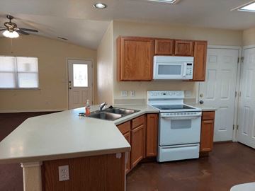 Marble Falls apartment for rent - A kitchen with brown cabinets and white appliances.