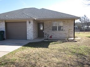 Marble Falls apartment for rent - A house with a brown garage door and a brick wall.