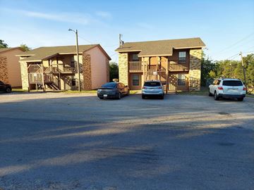 Marble Falls apartment for rent - A parking lot with two cars and two houses in the background.
