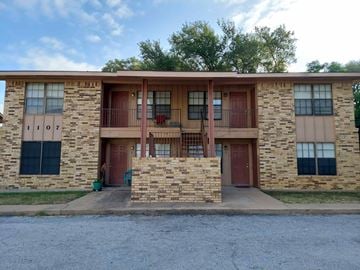 Marble Falls apartment for rent - A stone building with a red door and windows.